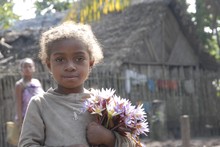 Enfants de Manakara, fillette porte un bouquet de fleurs